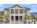 Charming home with a covered porch supported by columns and complemented by palm trees and a well-manicured lawn at 1305 Old Rice Mill Rd, Moncks Corner, SC 29461