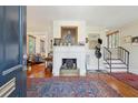 Inviting entryway featuring a fireplace, staircase, hardwood floors, and a colorful rug leading into the home at 135 Beaufain St, Charleston, SC 29401