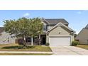 Charming home featuring a manicured lawn, mature tree, an attached two-car garage, and a welcoming covered entryway at 144 Marinella Dr, Goose Creek, SC 29445