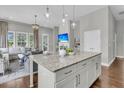 Kitchen island with granite counters overlooking living area with natural light at 1472 Longspur Dr, Mount Pleasant, SC 29466