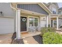 A welcoming front porch with rocking chairs, lush landscaping, and a decorative wreath on the front door at 152 Kirkland St, Goose Creek, SC 29445