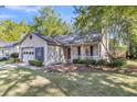 Single-story home with attached garage and cozy front porch, surrounded by trees at 153 Corsair St, Summerville, SC 29483