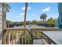 Balcony seating area overlooking community tennis courts and landscaped greenery on a sunny day at 1619 Live Oak Park, Johns Island, SC 29455