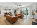 Open-concept living space with leather couches, a ceiling fan, and seamless access to a covered outdoor patio at 1644 Fort Palmetto Cir, Mount Pleasant, SC 29466