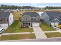 Picturesque aerial view of a two-story home with pond and neighborhood, with a spacious yard and two car garage at 205 Honey Horn Dr, Summerville, SC 29486