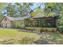 Beautiful home with a welcoming screened-in porch and lush front lawn, perfect for relaxing outdoors at 2144 Pinopolis Rd, Pinopolis, SC 29469
