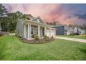 Charming home showcasing a welcoming front porch, attached garage, and landscaped yard at 221 Lucca Dr, Summerville, SC 29486