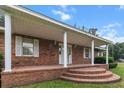 Inviting brick front porch with elegant white columns and a stepped entrance at 228 Dogwood Trl, Harleyville, SC 29448
