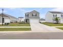 Two-story grey home features a two-car garage, black shutters, green grass, and ample driveway space at 244 Wild Strawberry Ln, Moncks Corner, SC 29461