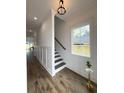 Bright hallway with wood-look floors, white walls with picture frame molding, stairs and a window at 2508 Corona St, North Charleston, SC 29405