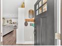 Warm entryway featuring hardwood floors, coat rack, and a glimpse of the open-concept living space at 255 S Railroad Ave, Ridgeville, SC 29472