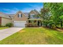Inviting two-story home with a well-maintained lawn, attached garage, and cozy front porch at 3025 Buckeley Cir, Charleston, SC 29414