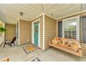 Cozy front porch with a hanging swing, wood furniture, and a welcoming wreath on the door at 3025 Buckeley Cir, Charleston, SC 29414