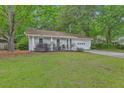 Well-maintained one-story home with a lush green lawn and mature trees for added privacy at 3230 Landing Pkwy, North Charleston, SC 29420