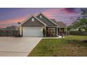 Charming home exterior with a well-manicured lawn, inviting driveway, and attached two-car garage at 3319 Dunwick Dr, Johns Island, SC 29455
