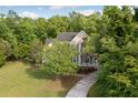 Beautiful two-story home surrounded by lush greenery with a long driveway in a wooded area at 4213 Club Course Dr, North Charleston, SC 29420
