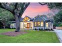 Beautiful home with a landscaped lawn and inviting entrance, illuminated in a colorful dusk at 422 Palm St, Mount Pleasant, SC 29464