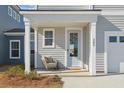 Inviting front porch featuring a light blue front door with a wreath, a chair, and house number 302 at 488 Queenview Ln, Charleston, SC 29414