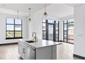 Modern kitchen island with stainless steel appliances, gold fixtures, and bright natural light at 5 Gadsdenboro St # 503, Charleston, SC 29401