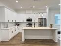 Modern kitchen featuring white cabinetry, stainless steel appliances, and a central island with countertop seating at 5841 Kirkwood Ave, North Charleston, SC 29406