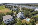 Stunning aerial view of the house with a private pool nestled amidst lush greenery and waterfront community at 6 Intracoastal Ct, Isle of Palms, SC 29451