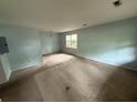 Bright and airy living room with large windows and neutral walls, providing a versatile space for relaxation and entertainment at 609 Coral St, Mount Pleasant, SC 29464