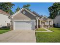 Inviting home with a two-car garage, stone-accented columns, and a lush green lawn and walkway at 632 Grassy Hill Rd, Summerville, SC 29483