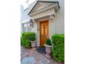 Elegant front entrance with wooden door, charming potted plants, and brick walkway at 8 Prioleau St # Th A, Charleston, SC 29401