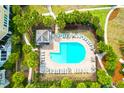 Aerial view of a community pool with lounge chairs, shaded cabana, and lush tropical landscaping at 8000 Palmetto Dr # 104-A, Isle of Palms, SC 29451