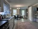 Bright, open kitchen with stainless steel appliances, granite countertops, and seamless flow into the dining and living areas at 8701 Caspiana Ln, North Charleston, SC 29420