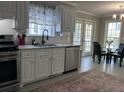 Bright kitchen featuring stainless steel appliances, white cabinetry, granite countertops, and a dining table by the French doors at 8701 Caspiana Ln, North Charleston, SC 29420