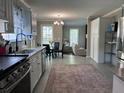Open-concept kitchen with stainless appliances and granite countertops, flowing into the dining area and cozy living space at 8701 Caspiana Ln, North Charleston, SC 29420