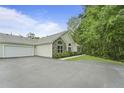 Charming single-story home with a paved driveway and an attached garage, surrounded by lush greenery at 8800 Dorchester Rd # 4001, North Charleston, SC 29420
