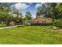 Inviting brick home with a lush green lawn, complemented by mature trees and vibrant landscaping at 902 Mikell Dr, Charleston, SC 29412