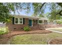 Traditional brick home with dark shutters, a walkway, and mature landscaping at 1023 Shelley Rd, Charleston, SC 29407