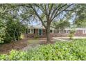 Traditional brick home with a well-maintained lawn and a mature shade tree at 1023 Shelley Rd, Charleston, SC 29407