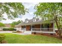 Beautiful brick home featuring a welcoming covered porch, complemented by lush green landscaping and a long driveway at 1100 Cass Dr, Moncks Corner, SC 29461