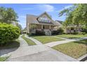 Attractive home with a spacious lawn, a front porch, and a curving driveway leading to a detached garage at 115 S Ainsdale Dr, Charleston, SC 29414