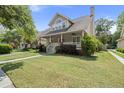 Inviting home with a covered front porch, lush green lawn, and mature trees enhancing its curb appeal at 115 S Ainsdale Dr, Charleston, SC 29414