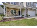 Inviting front porch with stone detailing, comfortable seating, and manicured landscaping at 118 Beacon Falls Ct, Summerville, SC 29486