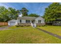 Charming home features a detached garage, green lawn, and inviting front porch at 1226 Forestwood Dr, Charleston, SC 29407
