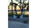 Cozy fire pit area with four Adirondack chairs, perfect for outdoor gatherings and enjoying the scenery at 123 Jungle Rd, Edisto Island, SC 29438