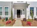 Inviting front entrance with a black door and well-manicured landscaping and home number at 129 Brown Swiss Cir, Summerville, SC 29483