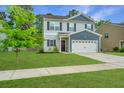 A two-story home with light grey siding, dark blue accents, and a beautiful green lawn at 141 Clydesdale Cir, Summerville, SC 29486