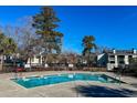 Community pool surrounded by lush trees and plenty of seating for residents at 1481 Center Street # 302, Mount Pleasant, SC 29464