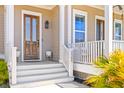 Inviting front porch with wooden door, lantern, and bright landscaping at 1580 Cranes Nest Rd, Mount Pleasant, SC 29466