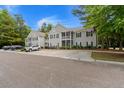Two-story condo building displaying light gray siding, black shutters, and mature trees at 1606 Whitby Ln, Charleston, SC 29414
