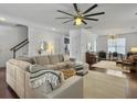 Spacious living room with hardwood floors, white walls, and a sectional sofa, open to other living spaces at 1753 Bee Balm Rd, Johns Island, SC 29455