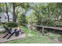 Picturesque backyard with a fire pit and seating area overlooking a tranquil stream and wooded landscape at 1938 Oak Tree Ln, Mount Pleasant, SC 29464