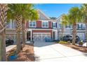 Charming two-story townhome featuring a garage, front yard landscaping, and a long driveway at 1992 Kings Gate Ln, Mount Pleasant, SC 29466